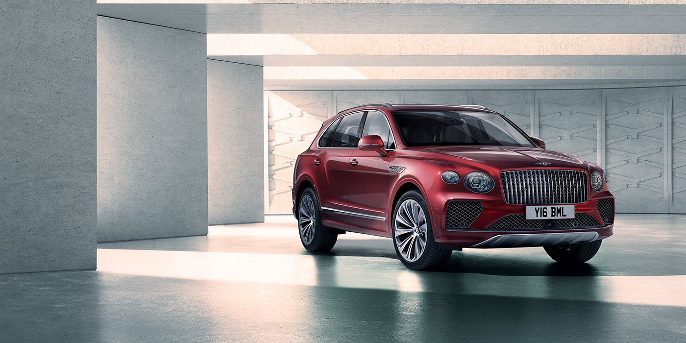 Bentley Leicester Bentley Bentayga Atelier Edition SUV in Rubino Red paint front three quarter against textured concrete wall