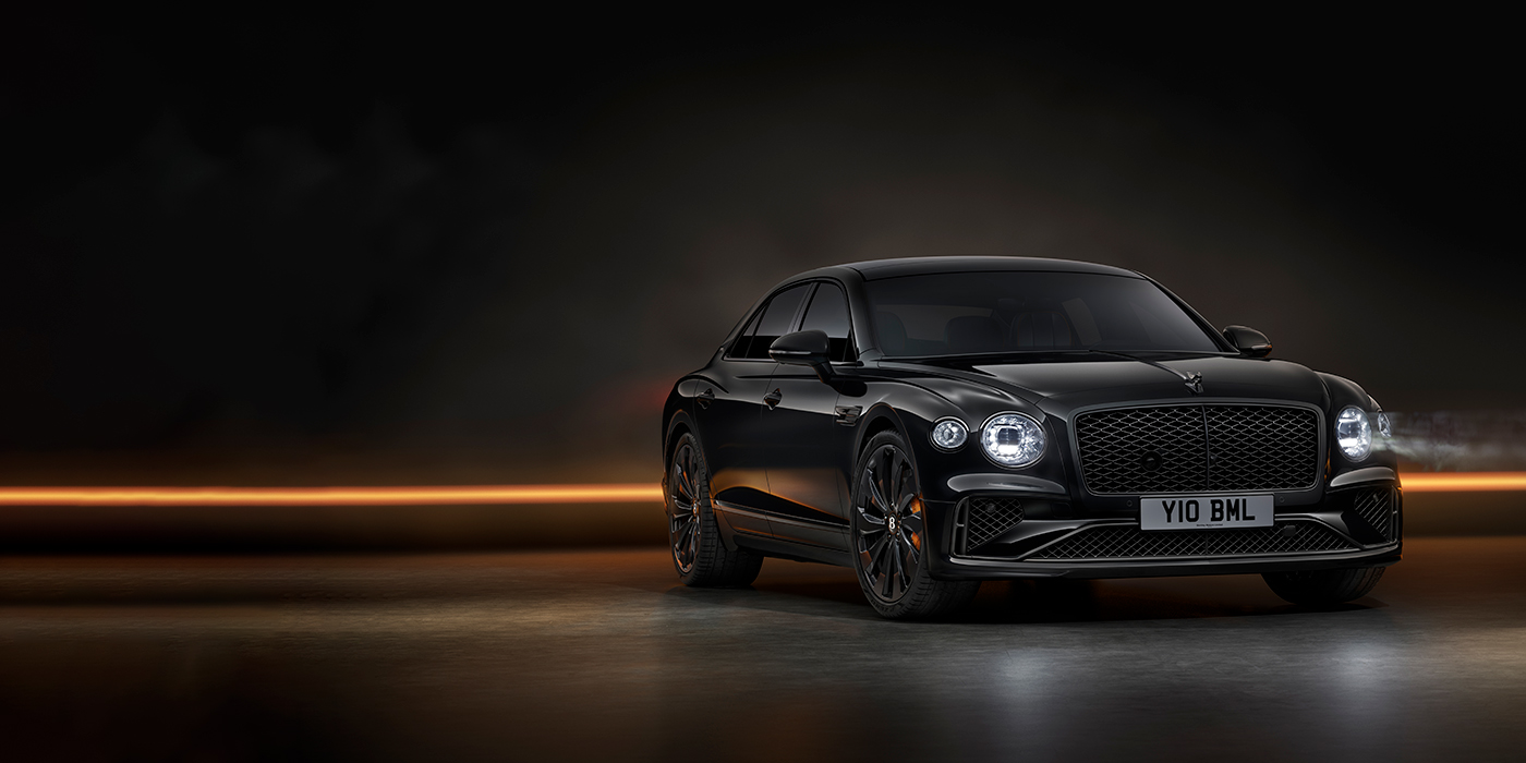 Bentley Leicester Bentley Flying Spur Black Edition sedan in Black Crystal paint against a dark grey and copper coloured background