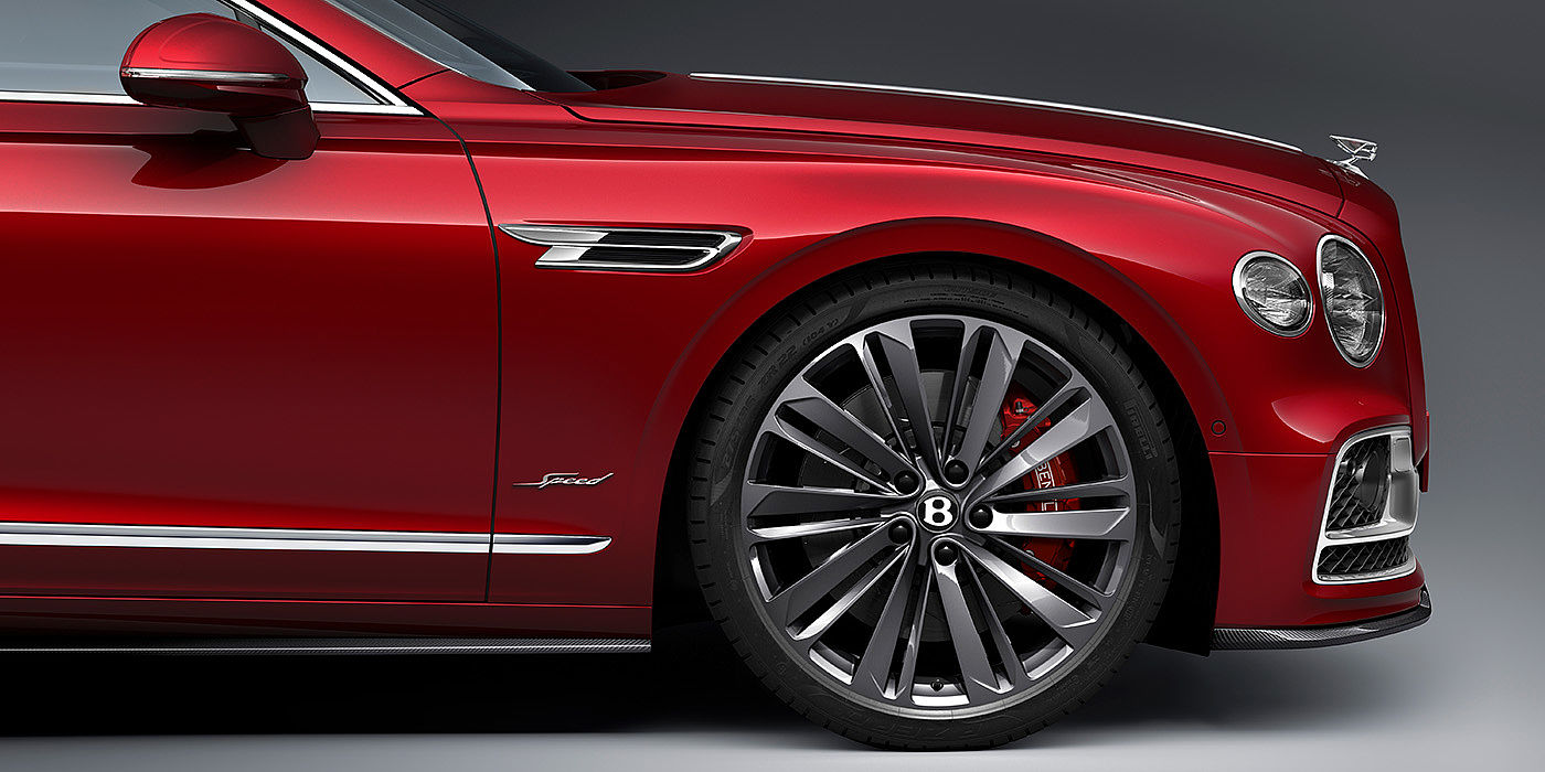Bentley Leicester Bentley Flying Spur Speed sedan front wheel in close up with Dragon Red II paint