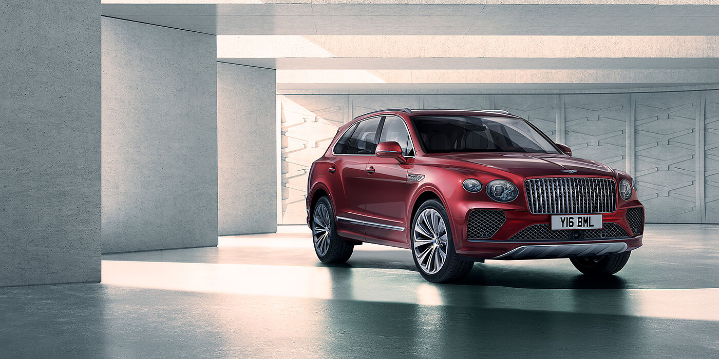 Bentley Leicester Bentley Bentayga Atelier Edition SUV in Rubino Red paint front three quarter against textured concrete wall