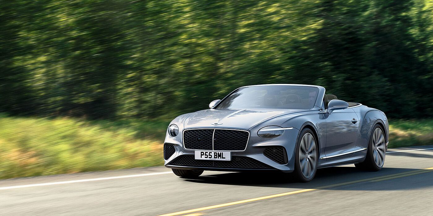 Bentley Leicester New Bentley Continental GTC convertible front view in Silverlake paint with 22 inch ten spoke wheels, driving dynamically on a country road
