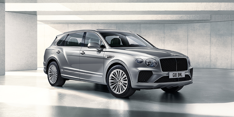 Bentley Leicester Bentley Bentayga Extended Wheelbase SUV front three quarter in Moonbeam paint with a grey background