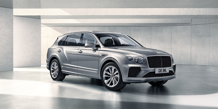 Bentley Leicester Bentley Bentayga Extended Wheelbase SUV front three quarter in Moonbeam paint with a grey background