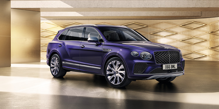 Bentley Leicester Bentley Bentayga Extended Wheelbase Mulliner SUV front three quarter in Tanzanite Purple paint with a gold patterned background