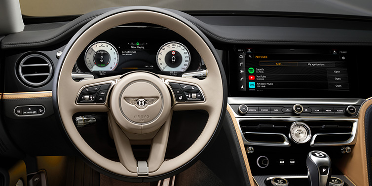 Bentley Leicester Bentley Flying Spur Mulliner sedan front interior detail of steering wheel and driver screens surrounded by Linen and Beluga black hides