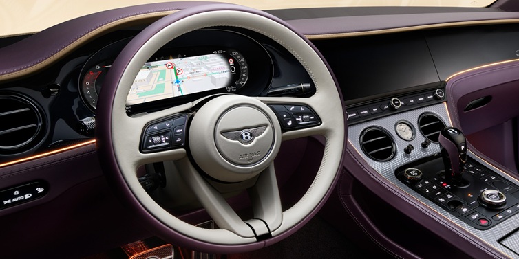 Bentley Leicester Bentley Continental GT Mulliner coupe front interior showing steering wheel and drivers screens surrounded by Linen and Damson hides and Grand Black veneer